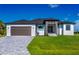 Beautiful single-story home boasts a well-manicured lawn, a two-car garage, and a modern stone-accented entryway at 8045 Bosco Rd, Port Charlotte, FL 33981