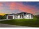 Well-manicured lawn leads up to this single-story home with a two car garage and modern accents at 8045 Bosco Rd, Port Charlotte, FL 33981