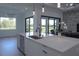 Open-concept kitchen with a large island, stainless steel dishwasher, and sliding glass doors to the backyard at 8045 Bosco Rd, Port Charlotte, FL 33981