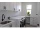Laundry room with modern appliances, cabinets, sink, and a built-in desk at 8045 Bosco Rd, Port Charlotte, FL 33981