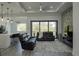 Spacious living room boasts a tray ceiling, ceiling fan, stone accent wall, and sliding glass doors at 8045 Bosco Rd, Port Charlotte, FL 33981