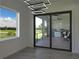 Bright living room with large windows, sliding glass doors, and modern lighting fixtures at 8045 Bosco Rd, Port Charlotte, FL 33981