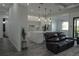 Open-concept space features a modern kitchen and living room with leather sofas and light gray flooring at 8045 Bosco Rd, Port Charlotte, FL 33981