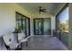 Relaxing screened patio features ceiling fans, tile floors, and sliding glass doors to the interior at 8045 Bosco Rd, Port Charlotte, FL 33981