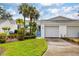 Charming villa with a two-car garage, mature palm trees, and a well-manicured lawn at 805 Waterside Ln, Bradenton, FL 34209