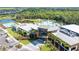 Aerial view of resort pool, ponds, trees, clubhouse, and parking lot in a community at 8705 Winter Breeze Way, Sarasota, FL 34241
