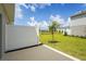 Serene backyard view with green lawn, privacy fence, and a tranquil pond in the distance at 8705 Winter Breeze Way, Sarasota, FL 34241