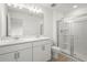 Bathroom featuring double sinks, neutral walls and a glass-enclosed shower at 8705 Winter Breeze Way, Sarasota, FL 34241