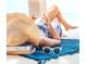 Person lounging on beach with a book, sunglasses, beach hat, and a blue cover at 1305 4Th St # 301G, Sarasota, FL 34236