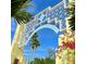 Bayfront entrance with an ornate design featuring palm trees, bougainvillea, and a blue sky backdrop at 1305 4Th St # 301G, Sarasota, FL 34236