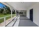Covered back porch with blue accent door, ample room for seating, and views of the backyard at 1408 99Th Nw St, Bradenton, FL 34209