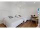 Well-lit bedroom with hardwood floors, two beds, a ceiling fan, and a desk area at 1408 99Th Nw St, Bradenton, FL 34209