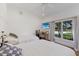 Bright bedroom featuring hardwood floors, two beds, a ceiling fan, and a window with backyard views at 1408 99Th Nw St, Bradenton, FL 34209