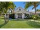 Inviting front of a white house with dark shutters, a covered porch, and meticulously manicured landscaping at 1408 99Th Nw St, Bradenton, FL 34209