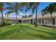 Stunning white home with a lush green lawn and mature palm trees, creating a serene tropical oasis at 1408 99Th Nw St, Bradenton, FL 34209