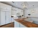 Elegant white kitchen with custom cabinetry, marble countertops, and a spacious island, complemented by designer lighting at 1408 99Th Nw St, Bradenton, FL 34209