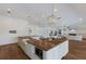Open-concept kitchen with white cabinets, a central wood island, and stainless steel appliances, flowing into the living area at 1408 99Th Nw St, Bradenton, FL 34209