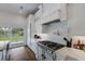 Modern kitchen featuring white cabinets, marble countertops, stainless steel appliances, and a door leading to an outdoor view at 1408 99Th Nw St, Bradenton, FL 34209
