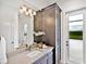 Chic bathroom featuring a modern vanity, decorative lighting, and a linen cabinet at 16917 Clearlake Ave, Lakewood Ranch, FL 34202