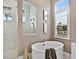 An elegant bathroom featuring a soaking tub and a large picture window at 16917 Clearlake Ave, Lakewood Ranch, FL 34202