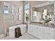 A well-lit bathroom with a soaking tub, marble floors, and a double sink vanity at 16917 Clearlake Ave, Lakewood Ranch, FL 34202