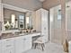 A primary bathroom featuring a vanity area and a walk-in shower with marble surround at 16917 Clearlake Ave, Lakewood Ranch, FL 34202