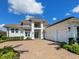 Elegant two-story home featuring a long brick driveway, three-car garage, and manicured landscaping at 16917 Clearlake Ave, Lakewood Ranch, FL 34202