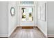 Inviting foyer showcasing a white double door entrance, hardwood floors and decorative wall art at 16917 Clearlake Ave, Lakewood Ranch, FL 34202