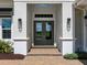 Stylish home entrance with elegant double doors, modern sconces, and a charming brick walkway at 16917 Clearlake Ave, Lakewood Ranch, FL 34202