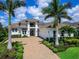A beautiful two-story home shows a large front yard and mature landscaping with a three car garage at 16917 Clearlake Ave, Lakewood Ranch, FL 34202