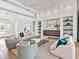 Bright and airy living room featuring stylish seating, custom built-ins, and tray ceiling at 16917 Clearlake Ave, Lakewood Ranch, FL 34202