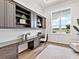 Stylish home office with custom built-in shelving, a sleek desk, and a window offering a serene view at 16917 Clearlake Ave, Lakewood Ranch, FL 34202