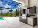 Modern outdoor kitchen boasts stainless steel appliances, sleek cabinetry, and a picturesque view at 16917 Clearlake Ave, Lakewood Ranch, FL 34202