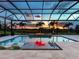 Gorgeous screened pool with a built-in fire pit and comfortable lounge chairs offers a relaxing outdoor experience at 16917 Clearlake Ave, Lakewood Ranch, FL 34202