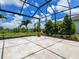 Screened-in pool area features travertine tile and view of landscaped yard at 16917 Clearlake Ave, Lakewood Ranch, FL 34202
