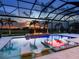 Gorgeous screened pool with a built-in fire pit and comfortable lounge chairs offers a relaxing outdoor experience at 16917 Clearlake Ave, Lakewood Ranch, FL 34202