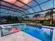 Beautiful screened pool with a built-in fire pit and comfortable lounge chairs offers a relaxing outdoor experience at 16917 Clearlake Ave, Lakewood Ranch, FL 34202
