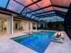 Beautiful pool featuring spa, gas fire feature, and colored lights in lanai at 16917 Clearlake Ave, Lakewood Ranch, FL 34202