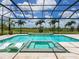 Luxurious pool and spa area surrounded by a screened enclosure and lush landscaping at 16917 Clearlake Ave, Lakewood Ranch, FL 34202