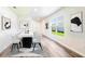 Bright dining room features contemporary table, white chairs, and modern art, with large window views at 17385 Whiskey Creek Trl, Parrish, FL 34219