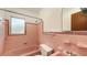 Retro pink bathroom featuring a bath tub, toilet, and sink at 2088 Grove St, Sarasota, FL 34239