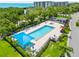 Community pool with a jacuzzi, covered seating area and well-maintained landscaping at 2181 Harbourside Dr # 1403, Longboat Key, FL 34228