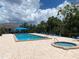 Community pool area with hot tub, lounge chairs, umbrellas, and well-maintained landscaping at 2181 Harbourside Dr # 1403, Longboat Key, FL 34228