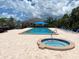 Community pool with a hot tub, lounge chairs and a shaded seating area for relaxation and enjoyment at 2181 Harbourside Dr # 1403, Longboat Key, FL 34228