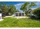 View of the backyard with a screened-in porch, gravel, and grass at 2189 Hillview St, Sarasota, FL 34239