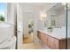 A bright bathroom features double sinks with wooden cabinets, plus an exterior view at 2189 Hillview St, Sarasota, FL 34239