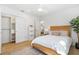 Well-lit bedroom with closet, wooden bedframe, white bedding, and light wood floors at 2189 Hillview St, Sarasota, FL 34239