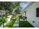 Home featuring a white fence, lush grass, a paved walkway, and landscaped plants at 2189 Hillview St, Sarasota, FL 34239