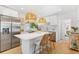 Stylish kitchen features stainless steel appliances, white cabinets, quartz countertops, and an island with seating at 2189 Hillview St, Sarasota, FL 34239