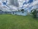 Expansive backyard with a well-maintained lawn and a charming light blue home, perfect for outdoor activities at 22214 Felton Ave, Port Charlotte, FL 33952